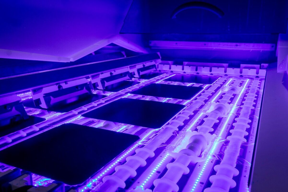 Scientists in a lab at Fraunhofer ISE examining advanced TOPCon solar cell technology under bright lights.