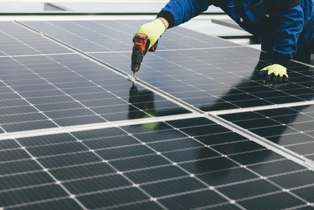 Solar panels being installed on a modern public building rooftop under a clear blue sky.