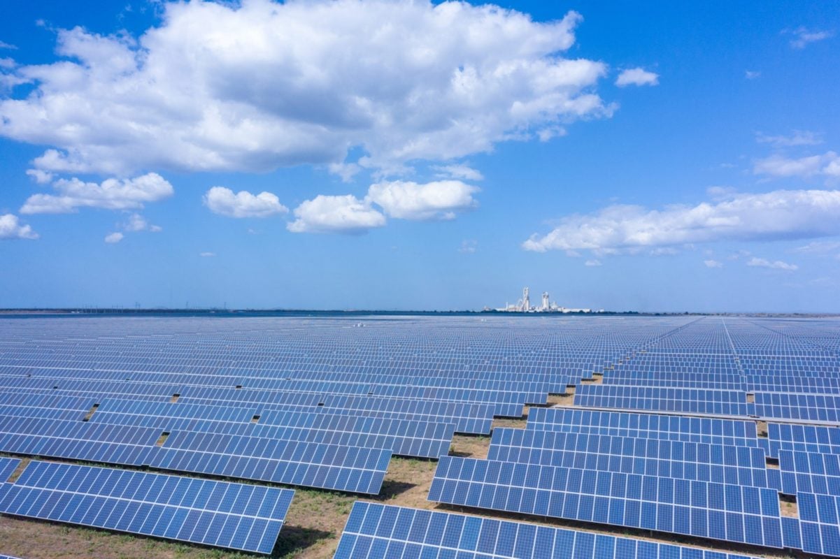 Aerial view of a massive 142MW utility-scale solar farm in Brazil showing rows of bifacial modules.