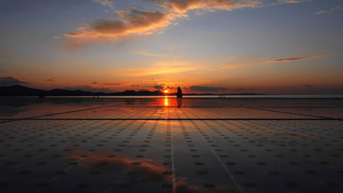 Solar panels installed in a desert landscape under a clear blue sky in Jordan.