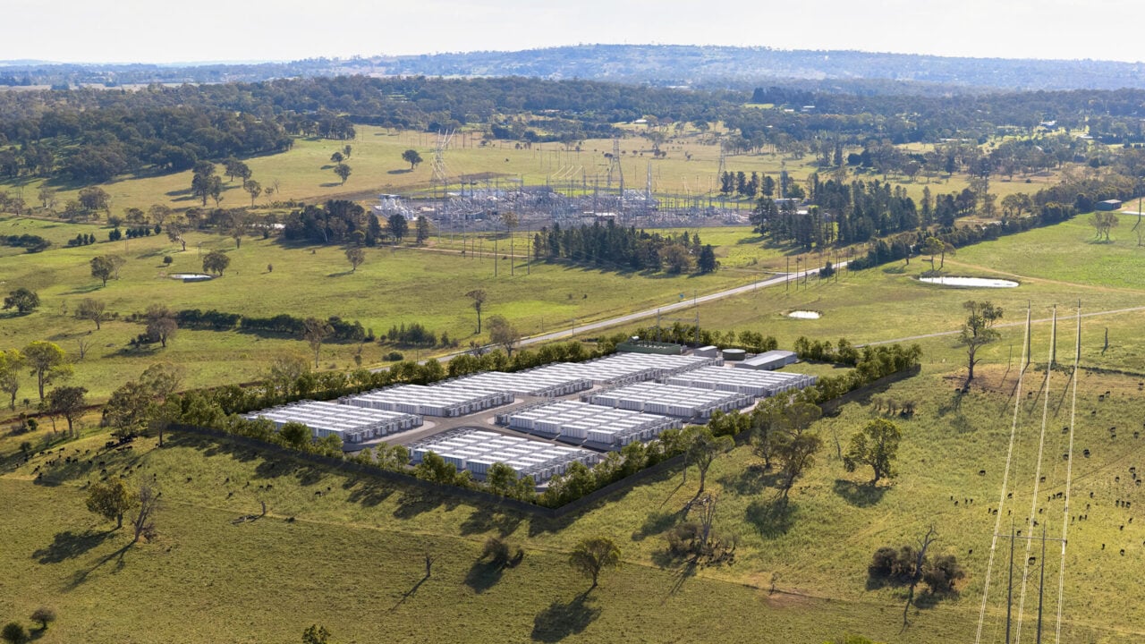 Large scale battery energy storage system containers in a field under a clear blue sky