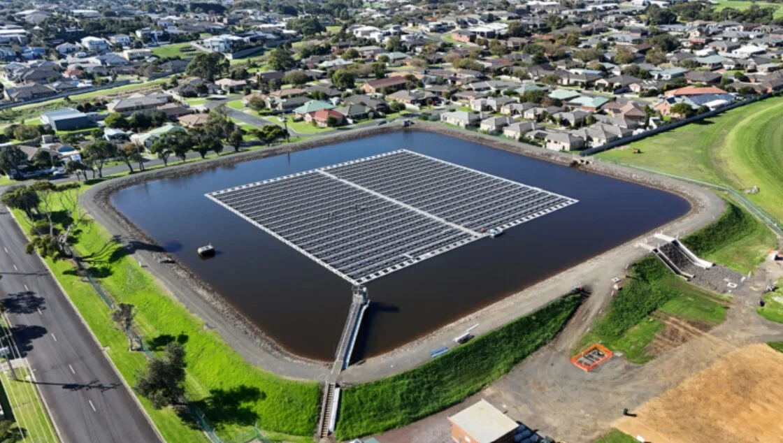 Large scale floating solar array with blue modules on high-density polyethylene pontoons at a utility reservoir.
