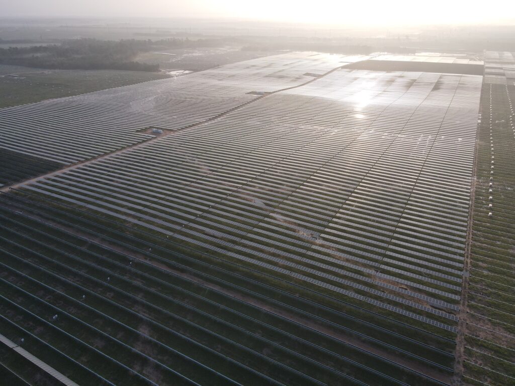 Graphic showing soaring global solar and wind installation figures against a backdrop of a European cityscape.