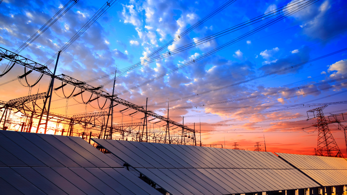 Large scale solar panels and electrical transformers representing the gap between installation and grid connection.
