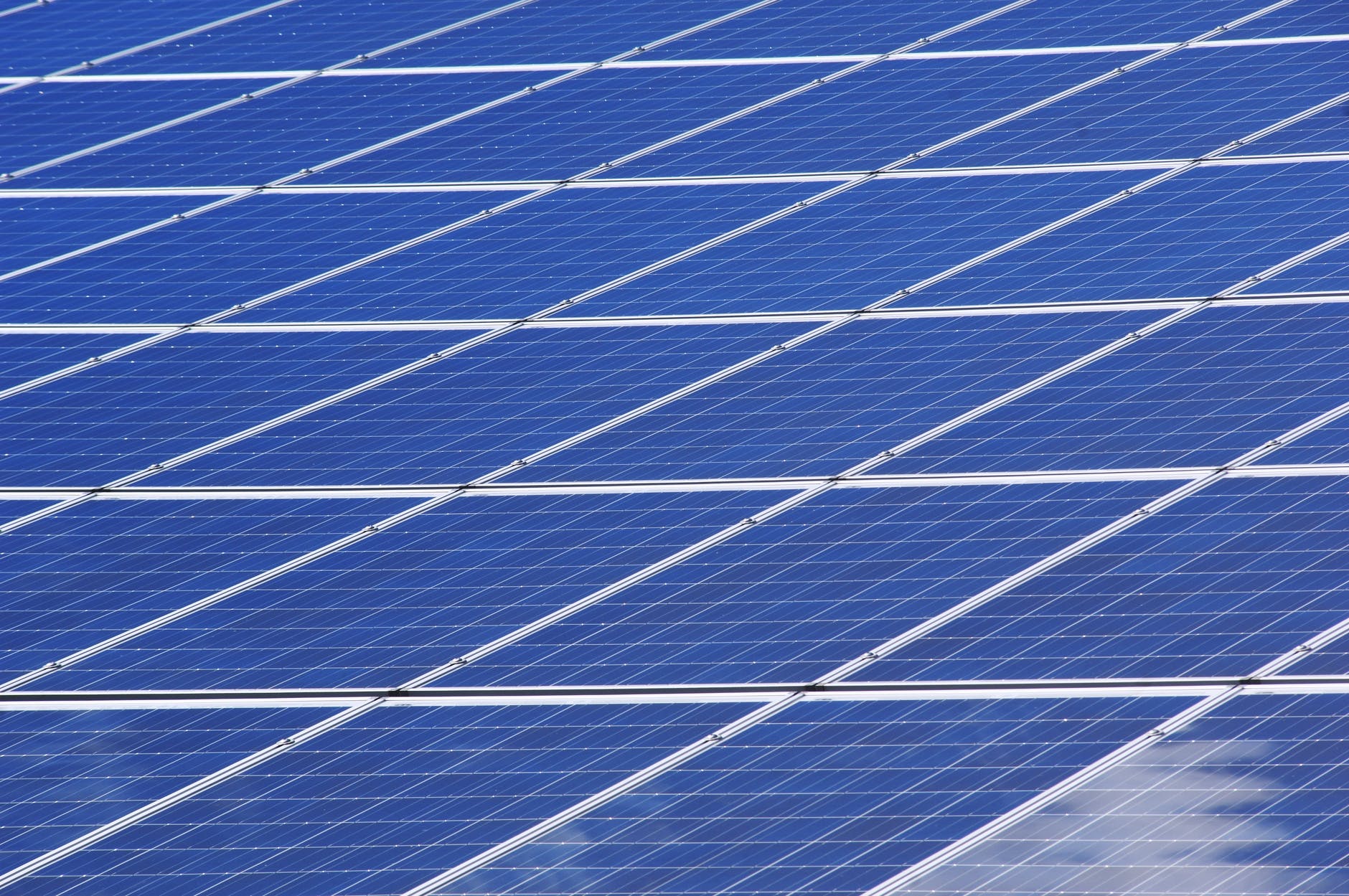 Large scale data center facility with solar panels on the roof and surrounding grounds.