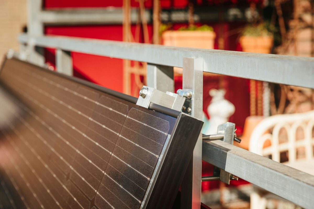 A modern apartment balcony equipped with a sleek, 1,200W plug-in solar panel system.