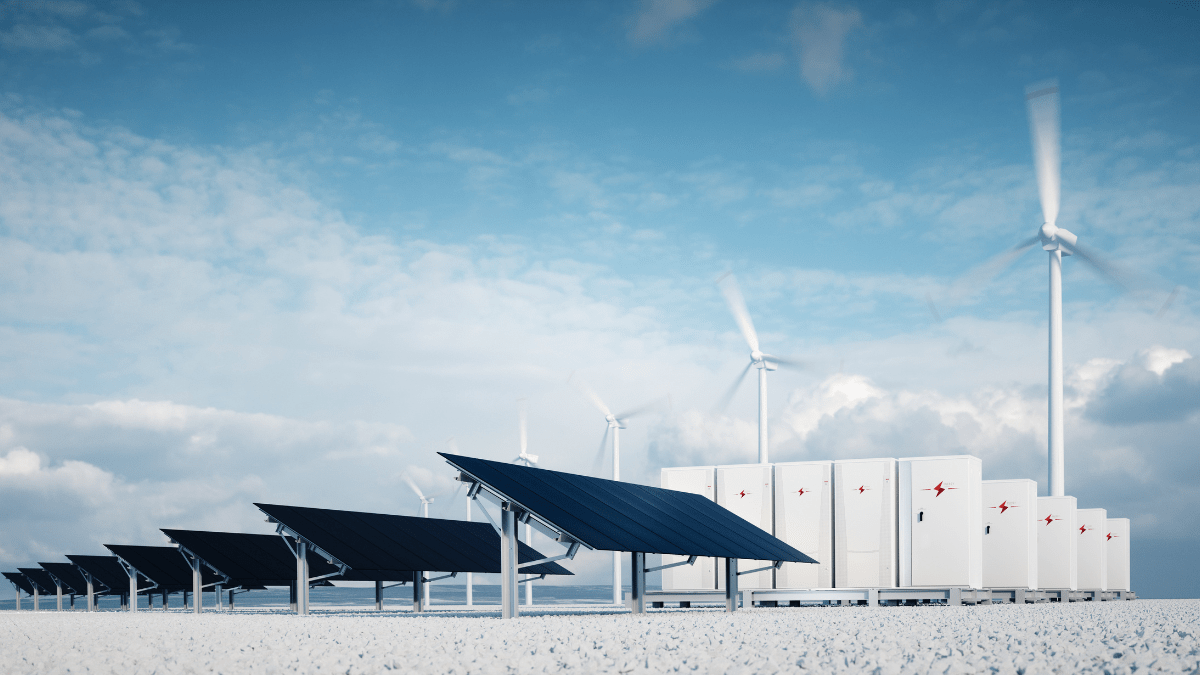 Aerial view of a large-scale solar farm with battery storage containers in a field