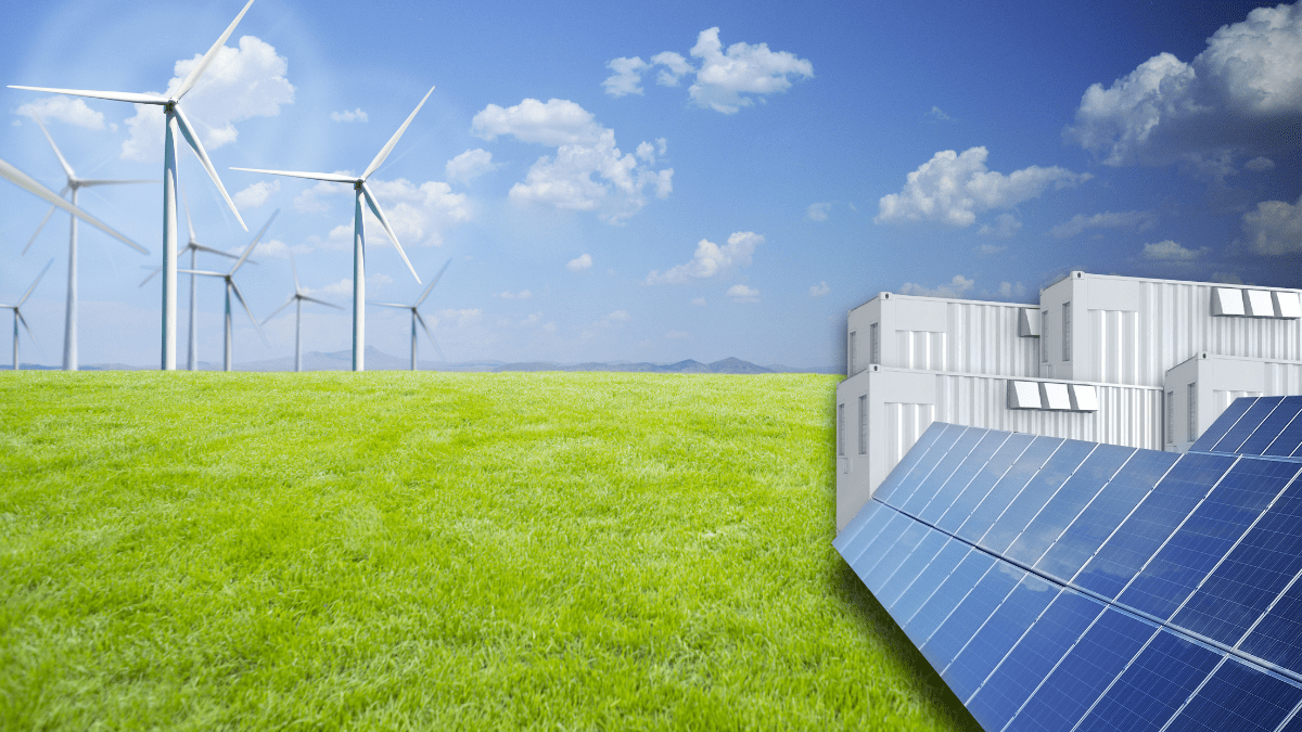Aerial view of a large-scale solar farm integrated with containerized battery storage units in a rural landscape.