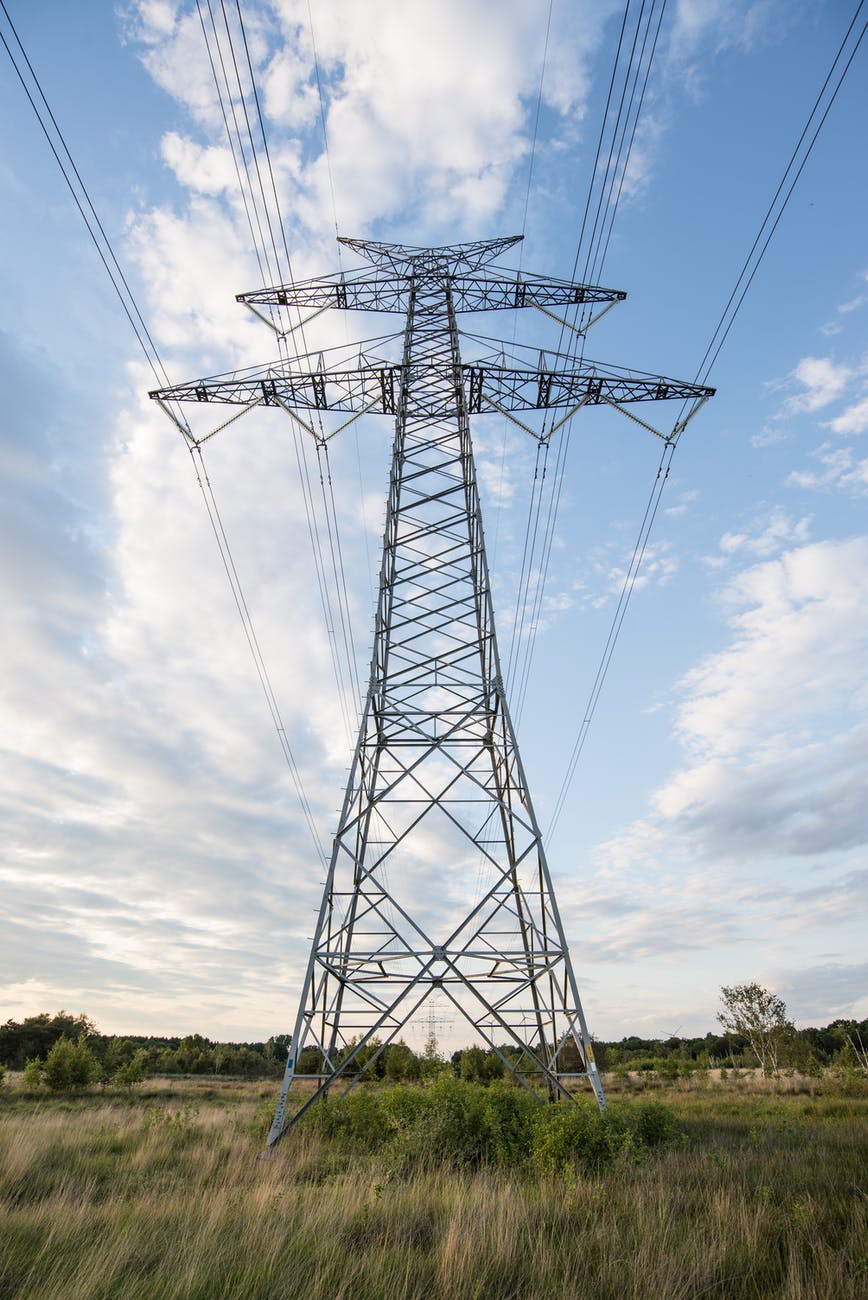 High voltage transmission pylon against a clear sky representing grid infrastructure