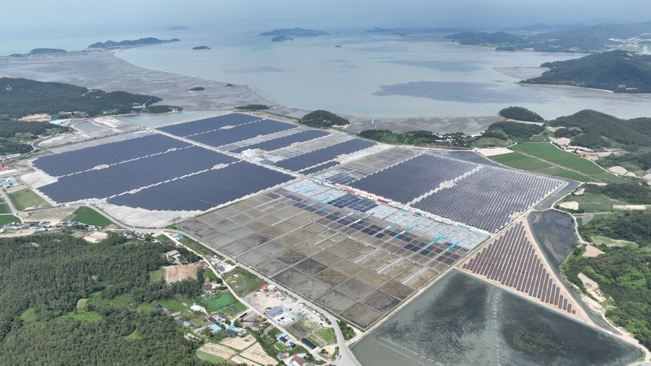 A large-scale solar farm with modern photovoltaic panels under a clear sky.