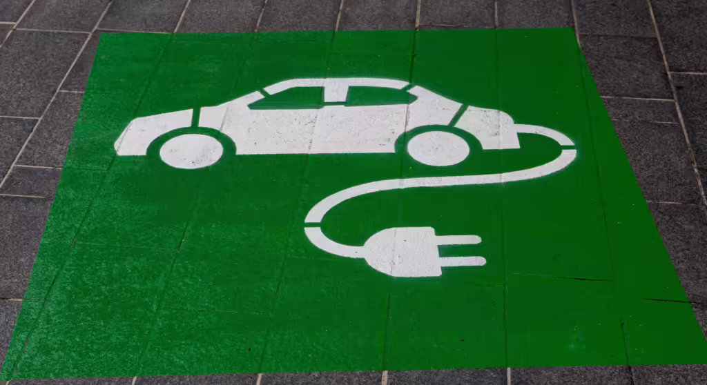 Technician installing a smart EV charging station connected to a residential solar PV array