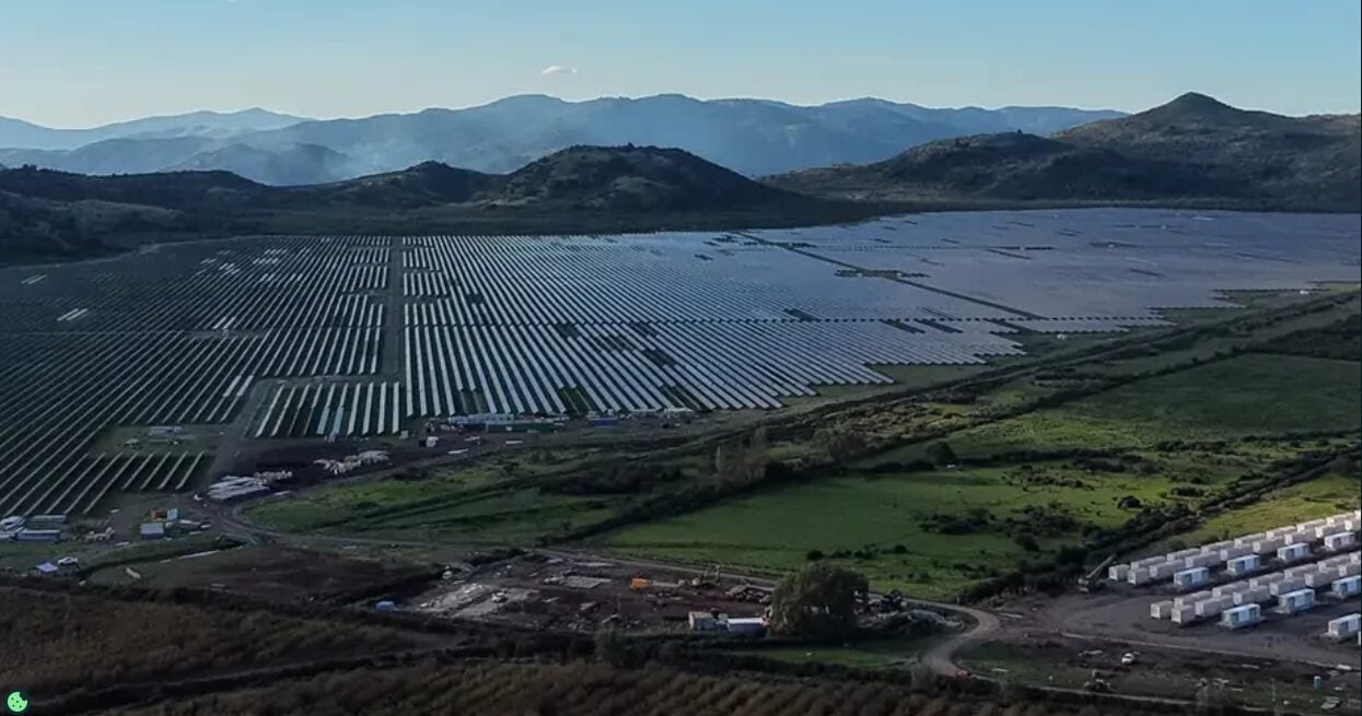 Large scale solar farm with integrated battery storage containers in a desert environment
