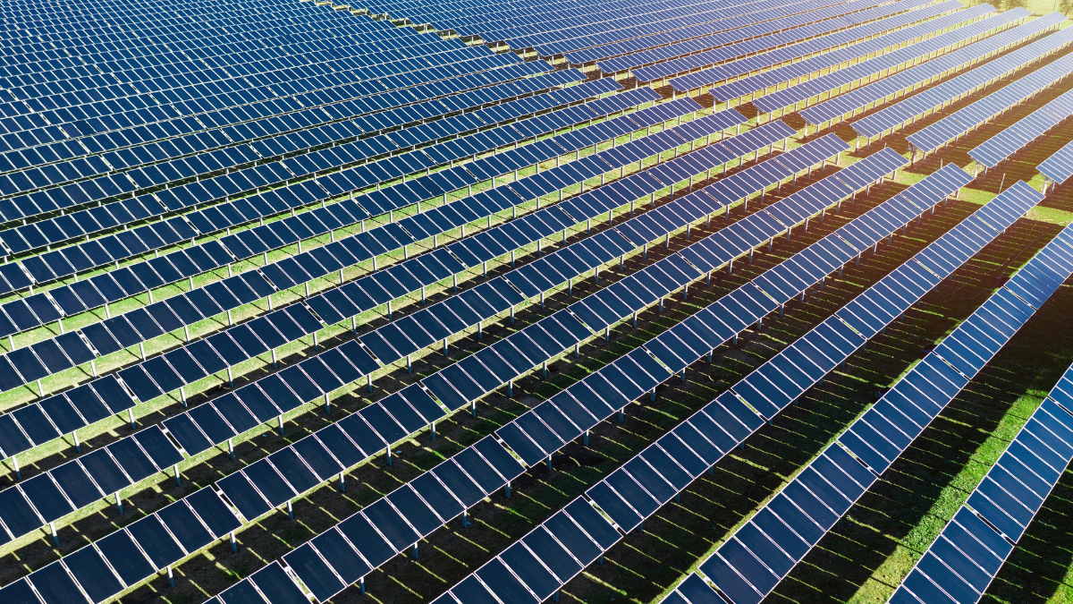 Aerial view of a large-scale solar array with containerized battery storage units in Bulgaria.
