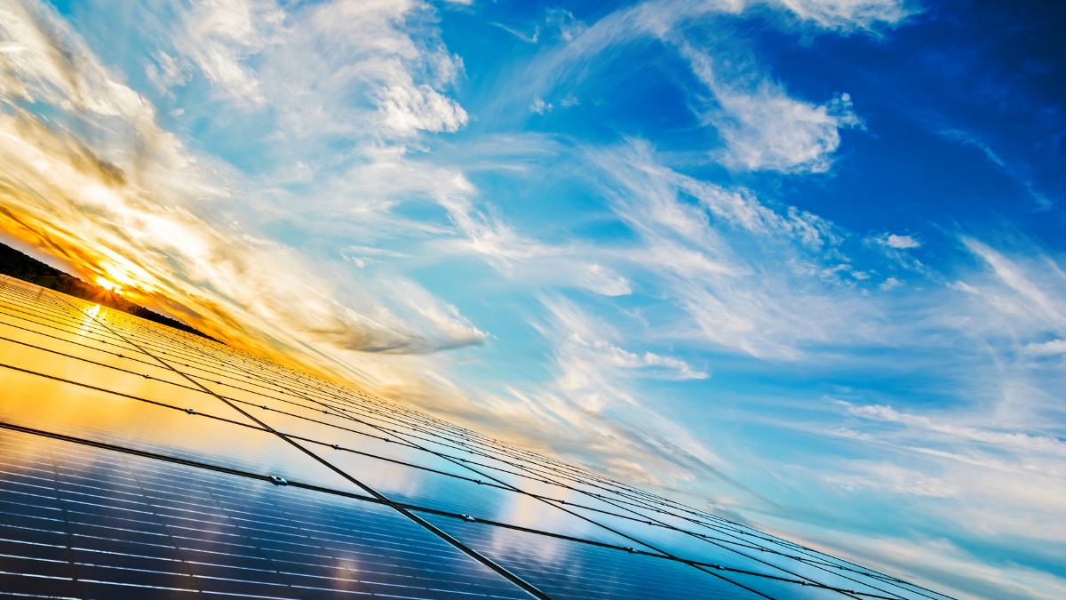 Aerial view of a large-scale solar farm installation under a clear blue sky