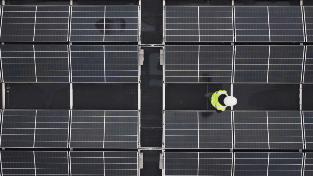 Aerial view of multiple rooftop solar installations in a Spanish town forming an energy community