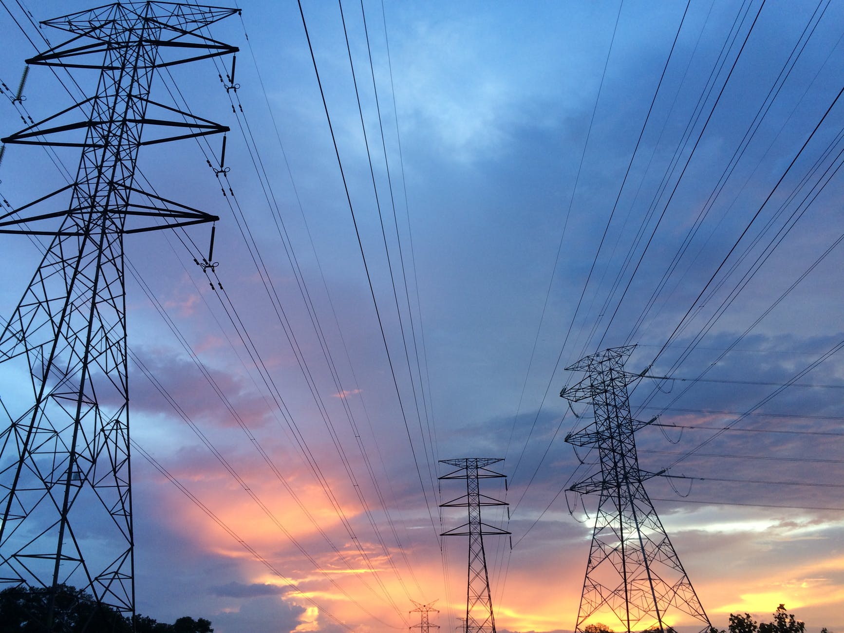 Abstract view of power lines and electricity infrastructure against a blue sky