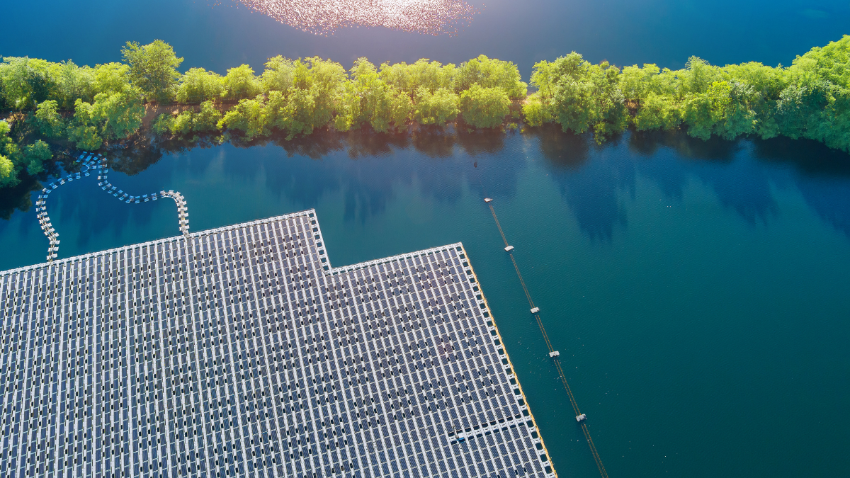 Large scale floating solar array installation on a calm water reservoir with blue sky