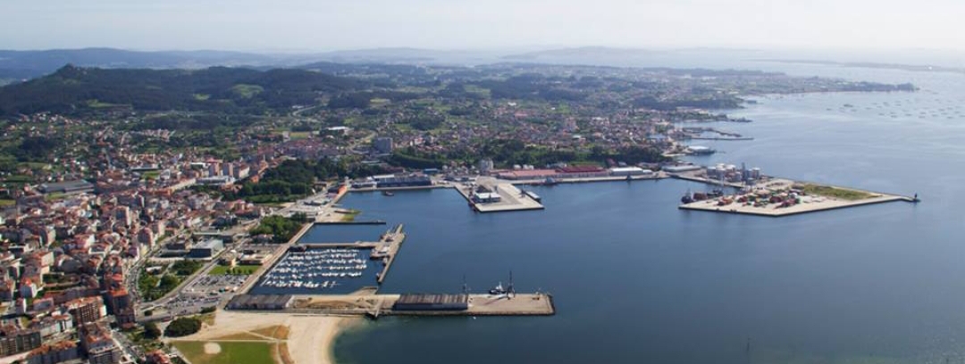 Industrial port infrastructure with solar panels on a warehouse roof near the ocean