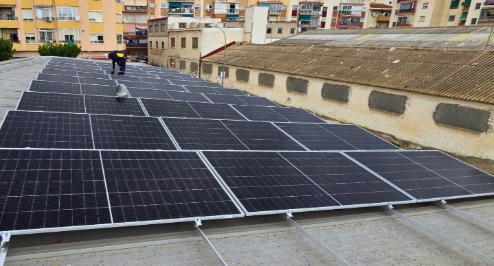 Solar panels installed on the rooftop of a large municipal sports center in Spain
