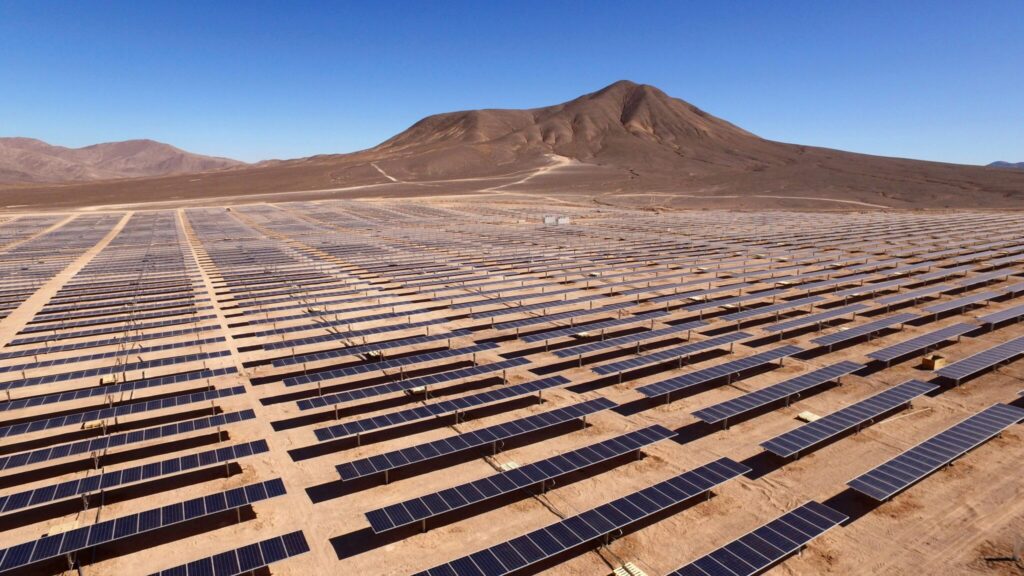 A large-scale solar farm under a blue sky, representing utility project development in Spain.