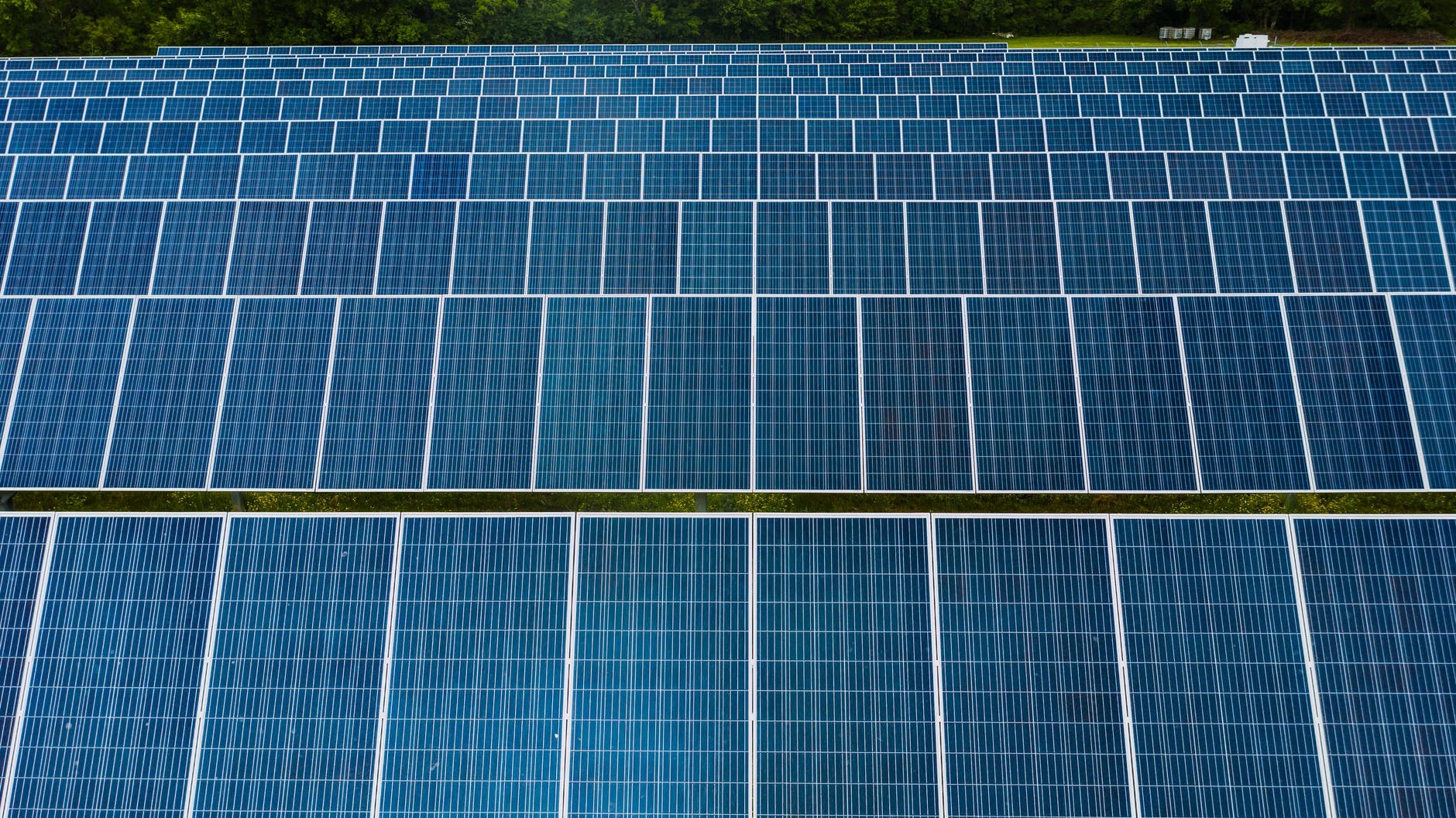 Aerial view of a large-scale industrial solar installation on a factory rooftop.