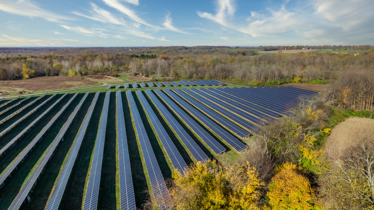 Aerial view of a large utility-scale solar farm integrated with industrial manufacturing infrastructure